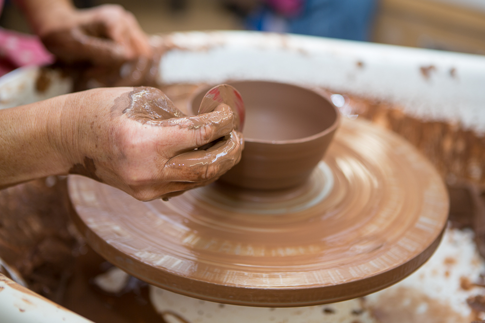 Close up of a student using the potter's wheel at The Ceramics Studio