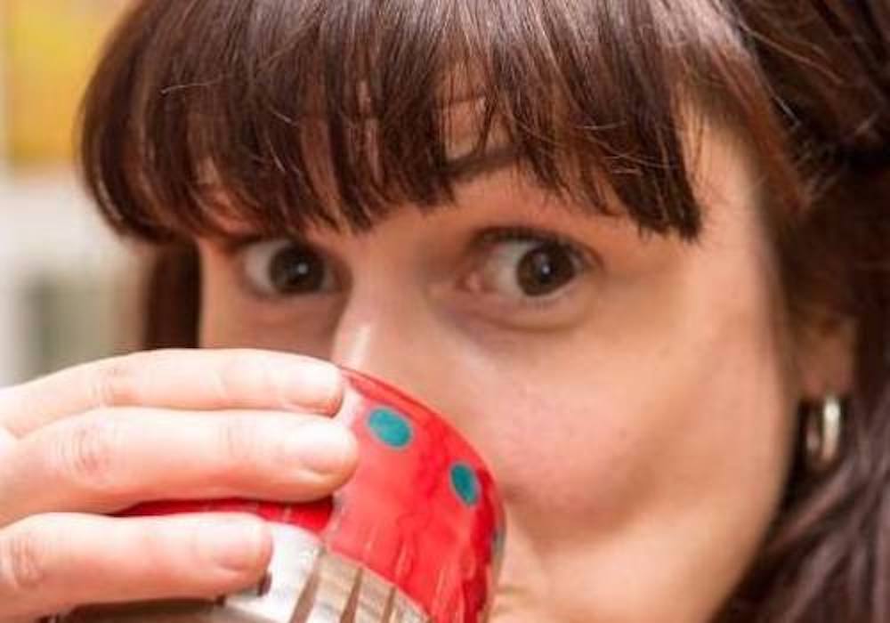 Leyla Folwell drinking tea from a red handmade ceramic cup